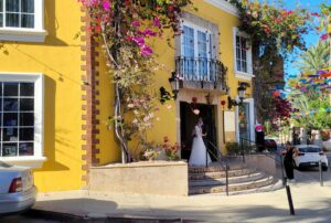 Newlyweds in a door of a yellow building of a restaurant