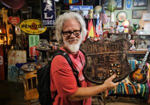 a man holding the oldest road 66 oklahoma sign
